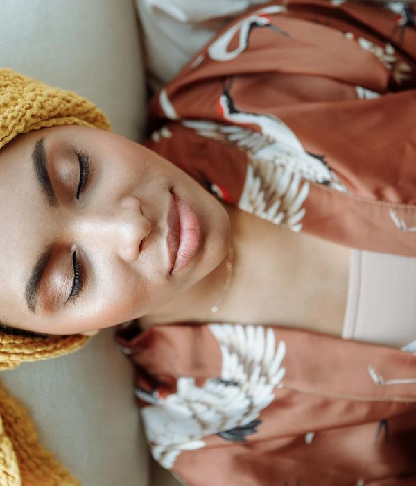 Woman with a serene expression enjoying a gentle morning exercise routine indoors.